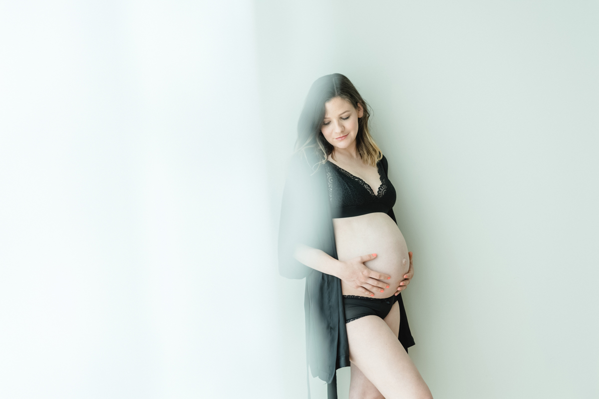 Schwangere Frau hält liebevoll ihren Babybauch